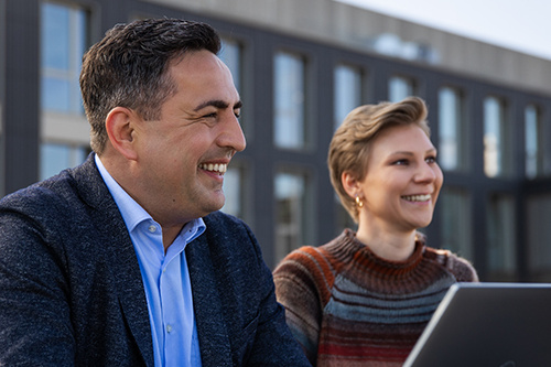 Zwei Mitarbeitende sitzen auf der Dachterrasse der SDK.