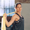 Eine Frau macht Yoga mit einem Stretch-Band.