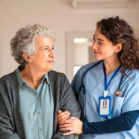 Eine Altenpflegerin kümmert sich um eine alte Frau.