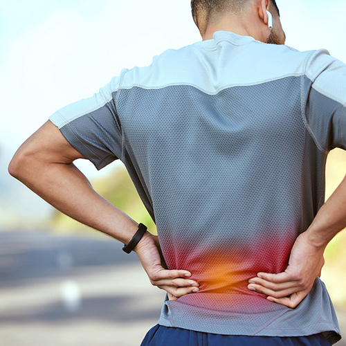 Mann hat Rücken&shy;schmerzen.