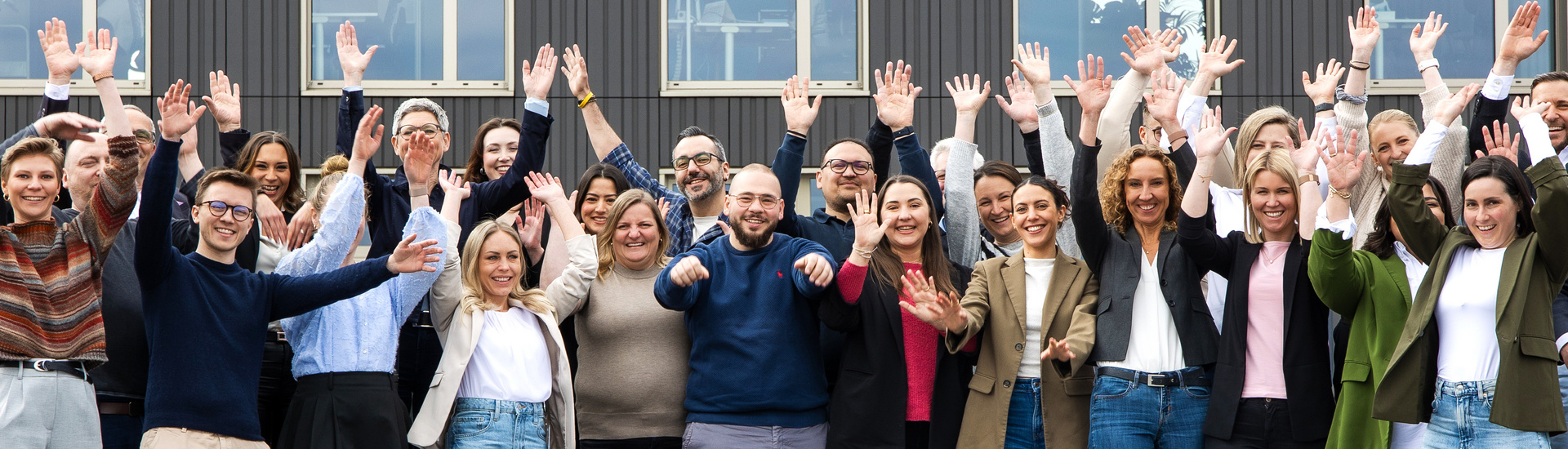 Eine große Gruppe von fröhlichen SDK Mitarbeitern vor der Hauptverwaltung in Fellbach.