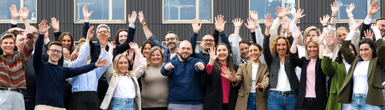Eine große Gruppe von fröhlichen SDK Mitarbeitern vor der Hauptverwaltung in Fellbach.