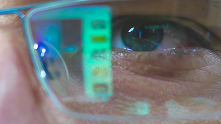 In einer Brille mit Blaulichtfilter spiegelt sich ein Bildschirm wider.