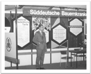 Historische Aufnahme eines Mannes vor Versicherungsplakaten, 1957