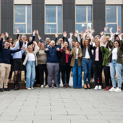 Auf dem Foto jubeln zahlreiche Mitarbeitende der SDK voller Freude.