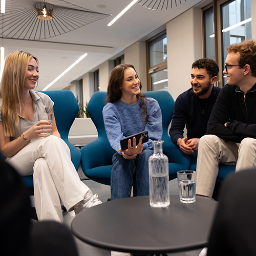 Eine Gruppe von Werkstudierenden bei der SDK unterhält sich.