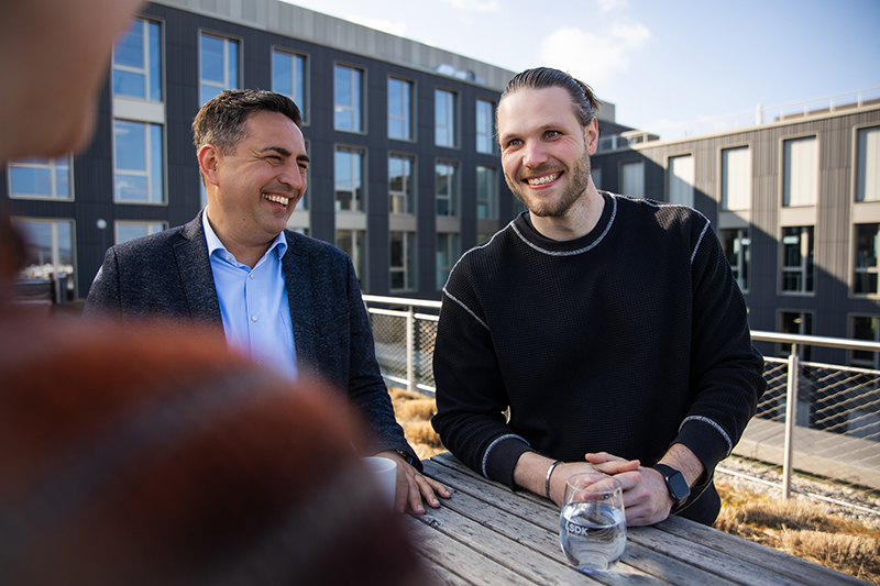 Drei SDK-Mitarbeitende auf der Dachterrasse.